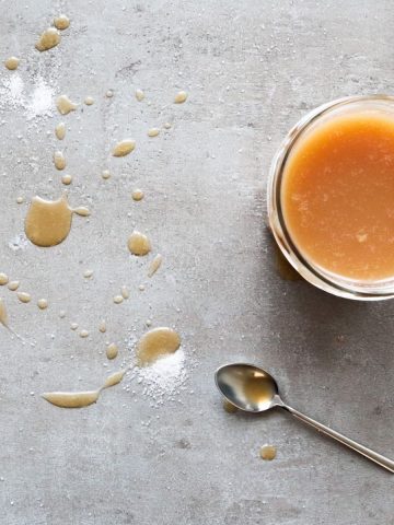 Caramel sauce with sea salt on a grey background.