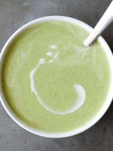 Vegan courgette soup in a bowl with a spoon.