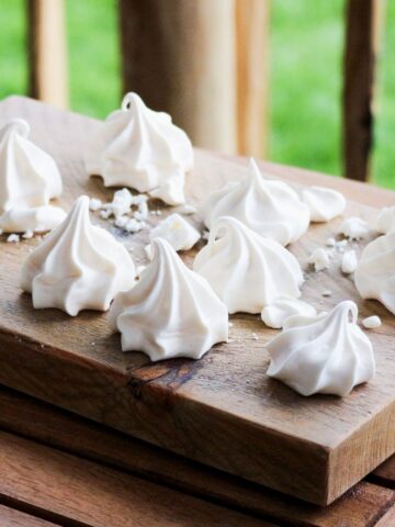 Meringue kisses on a wooden plate.